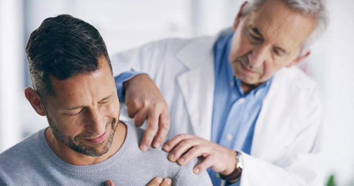 man at doctor getting his shoulder examined
