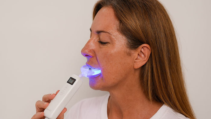 woman using red light therapy in her mouth